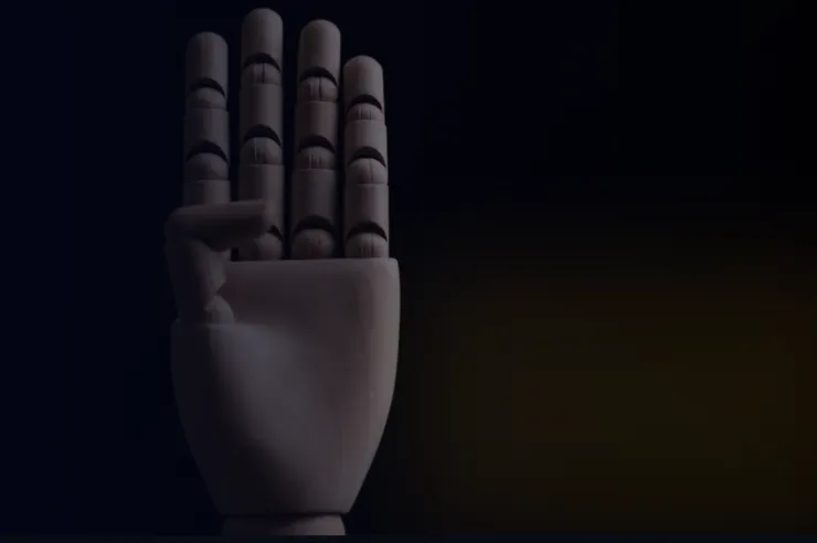 Wooden mannequin hand raised against a dark background